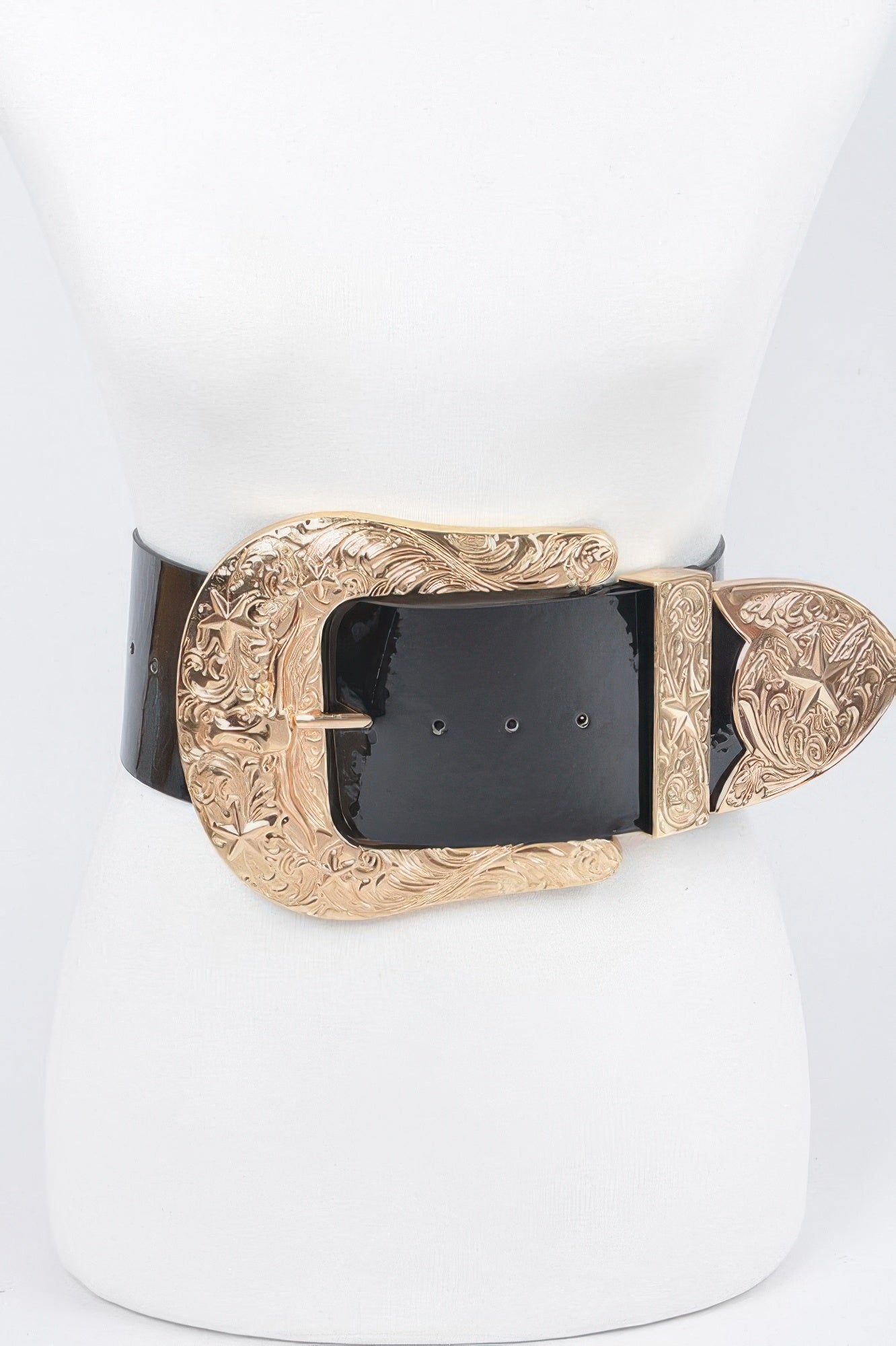Oversized waist belt: black enamel strap with gold engraved buckle and decorative end pieces.