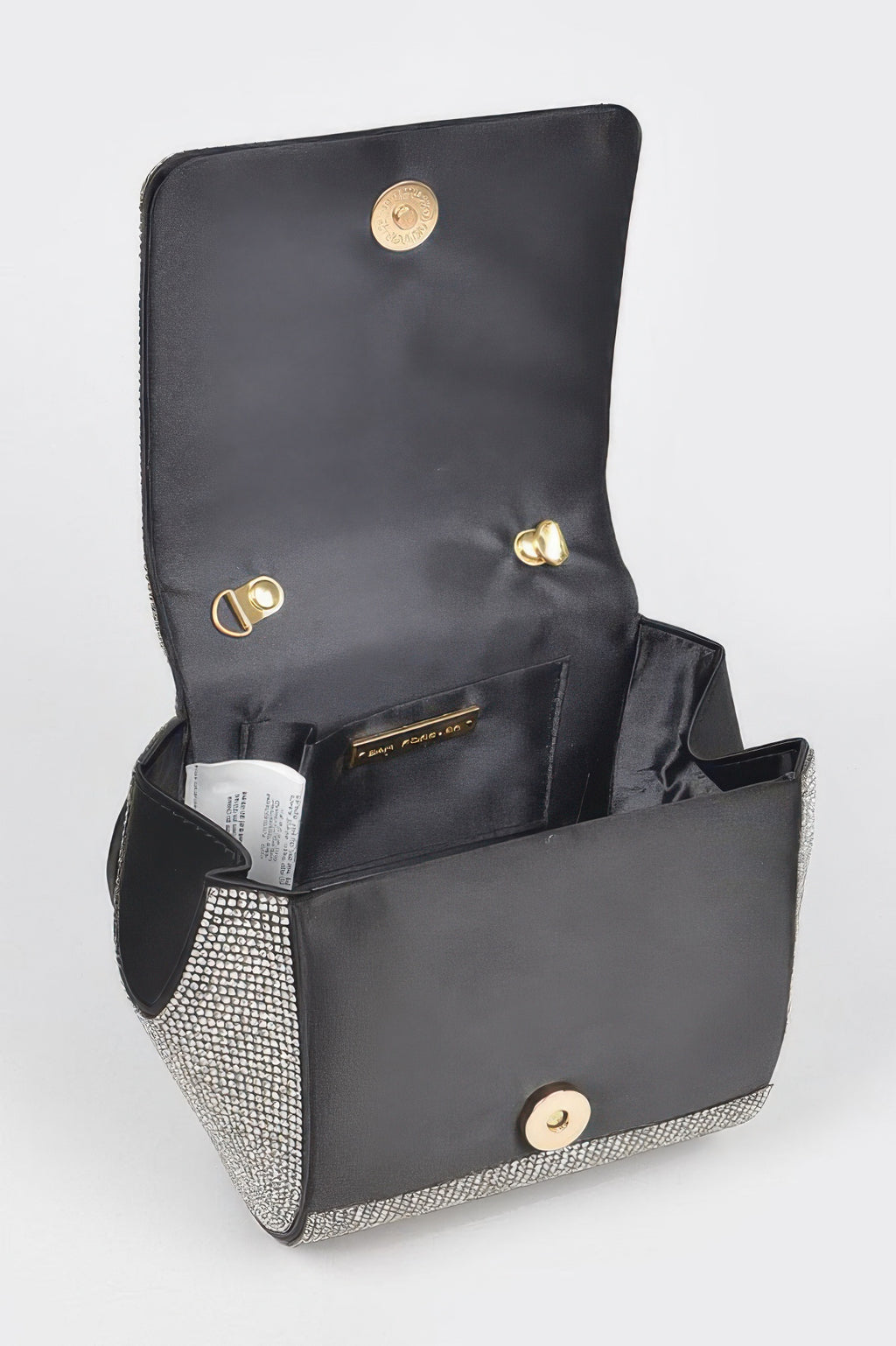 Open rhinestone flap clutch showing black lining, pockets, and gold snap clasp