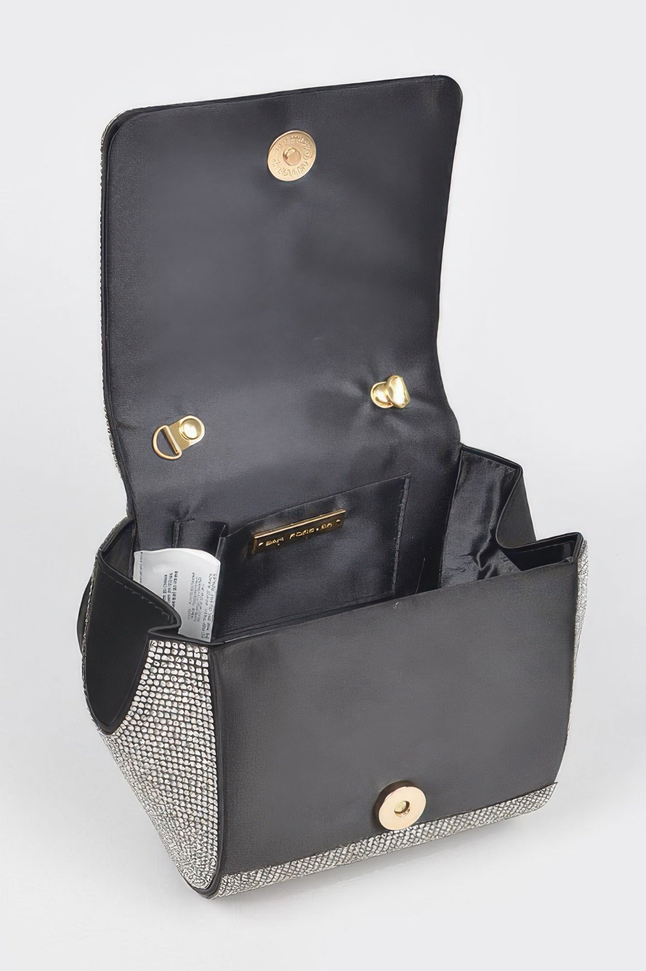 Open rhinestone flap clutch showing black lining, pockets, and gold snap clasp