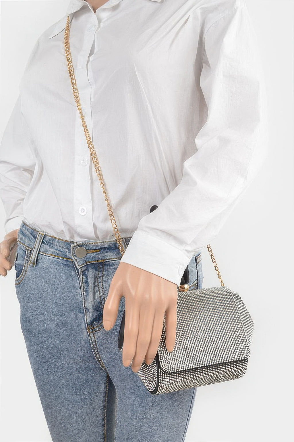 Rhinestone wristlet clutch worn with gold chain and black handle strap