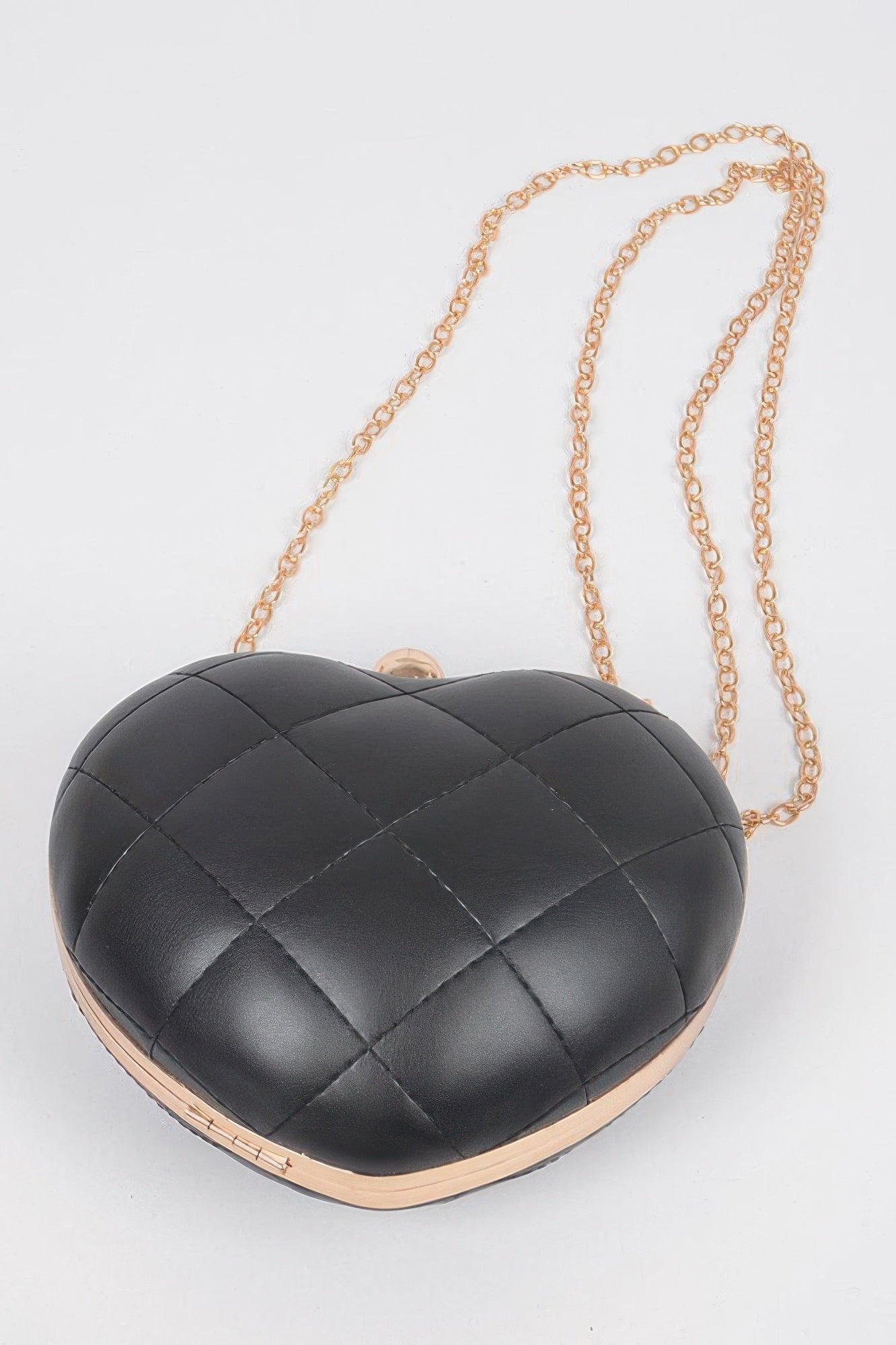 Black quilted heart crossbody bag with gold chain and rounded clasp hardware