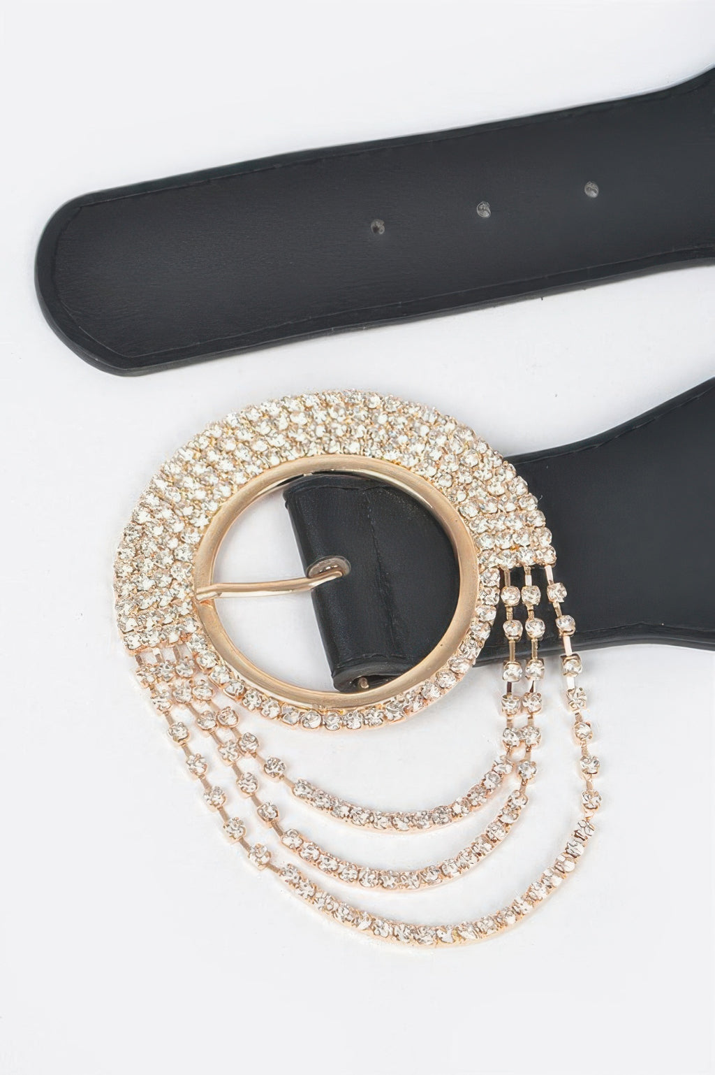 Close-up: gold-toned rhinestone round buckle on black elastic belt with layered chains