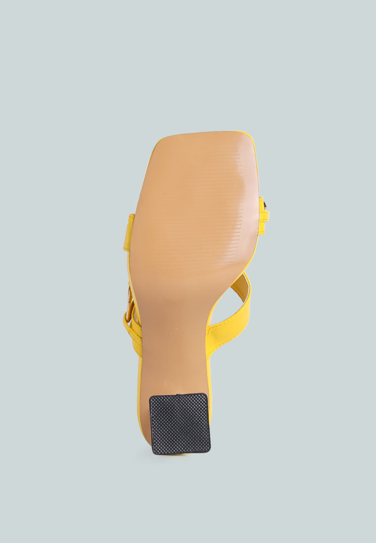 Yellow sandal outsole view with black traction pad on the heel.