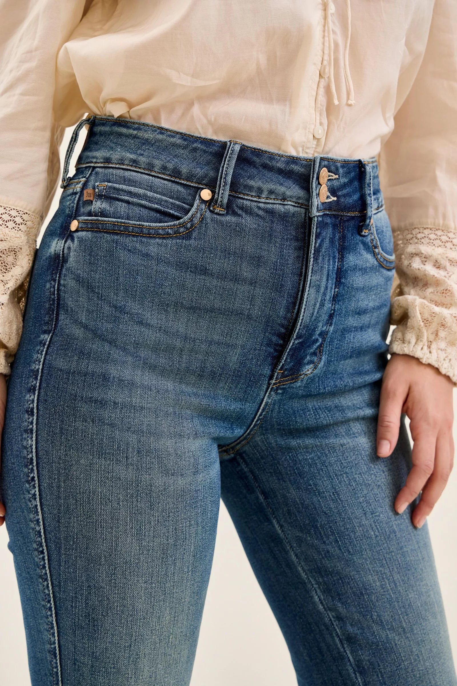 Dark denim high-waist jeans close-up, center seam and double-button waistband