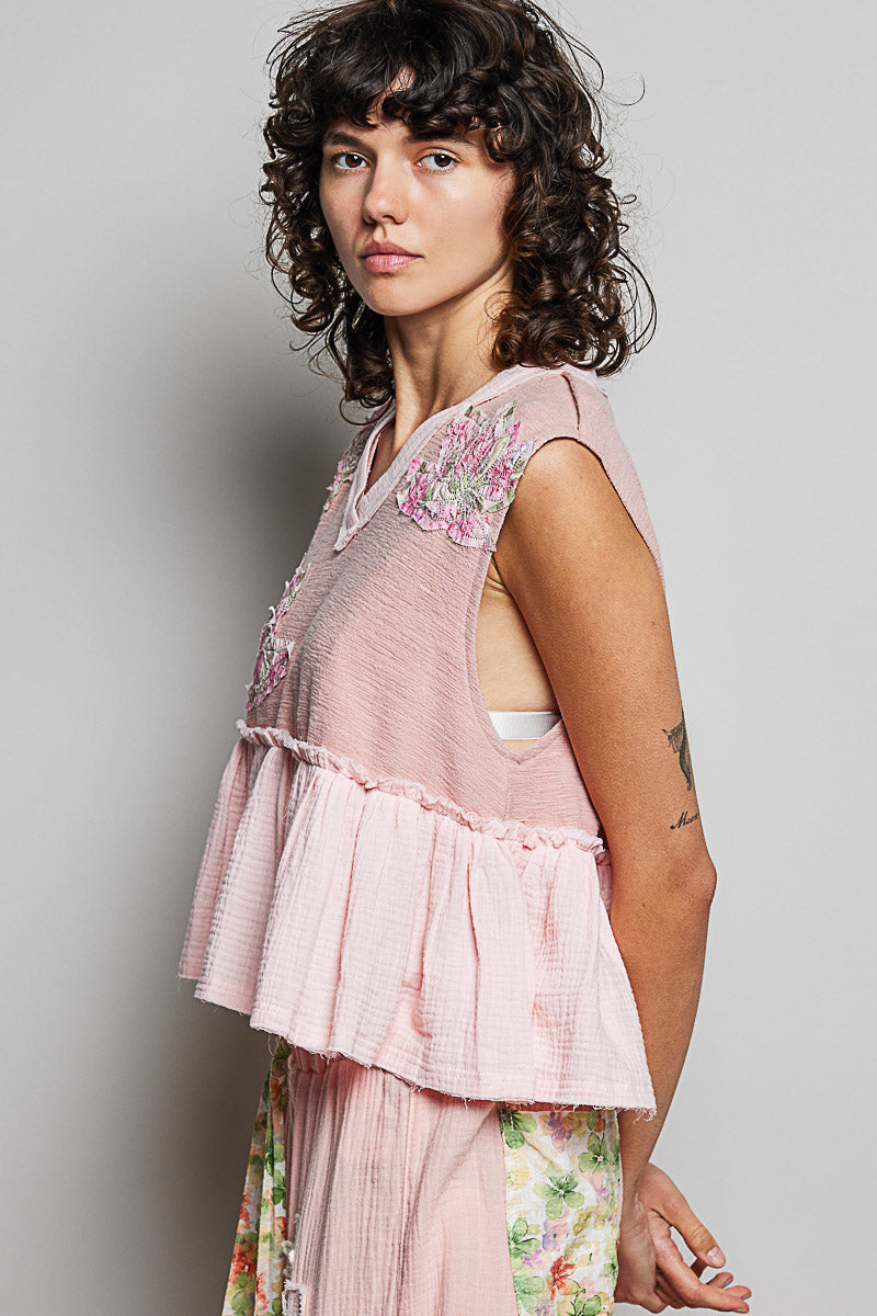 Powder pink sleeveless top, floral shoulder patch and tiered ruffle peplum