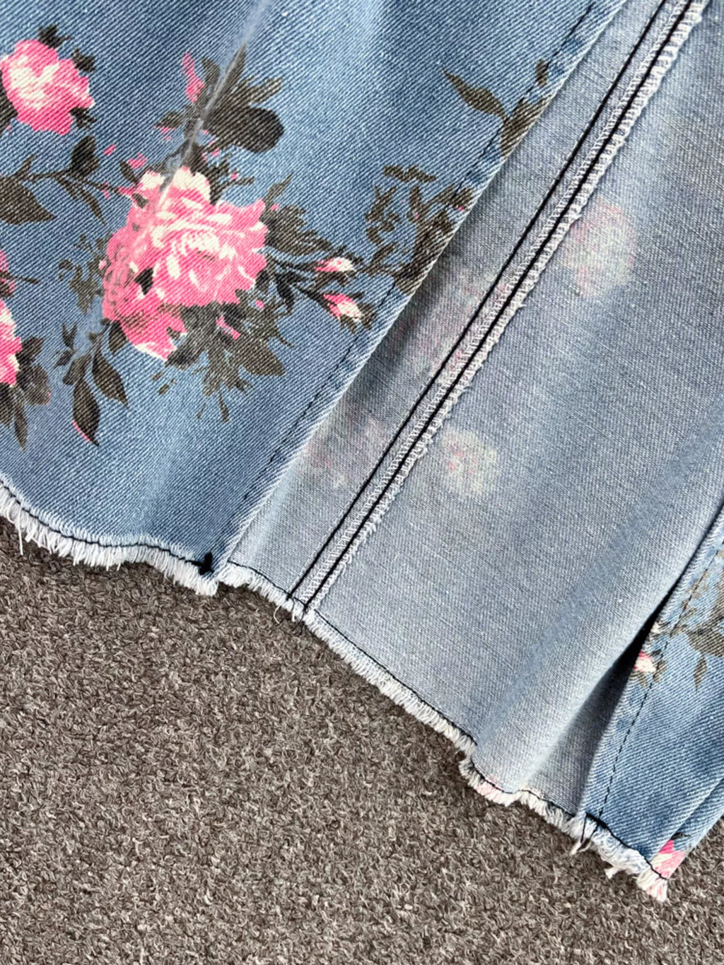 Blue denim skirt hem with pink floral border and raw-edged fray