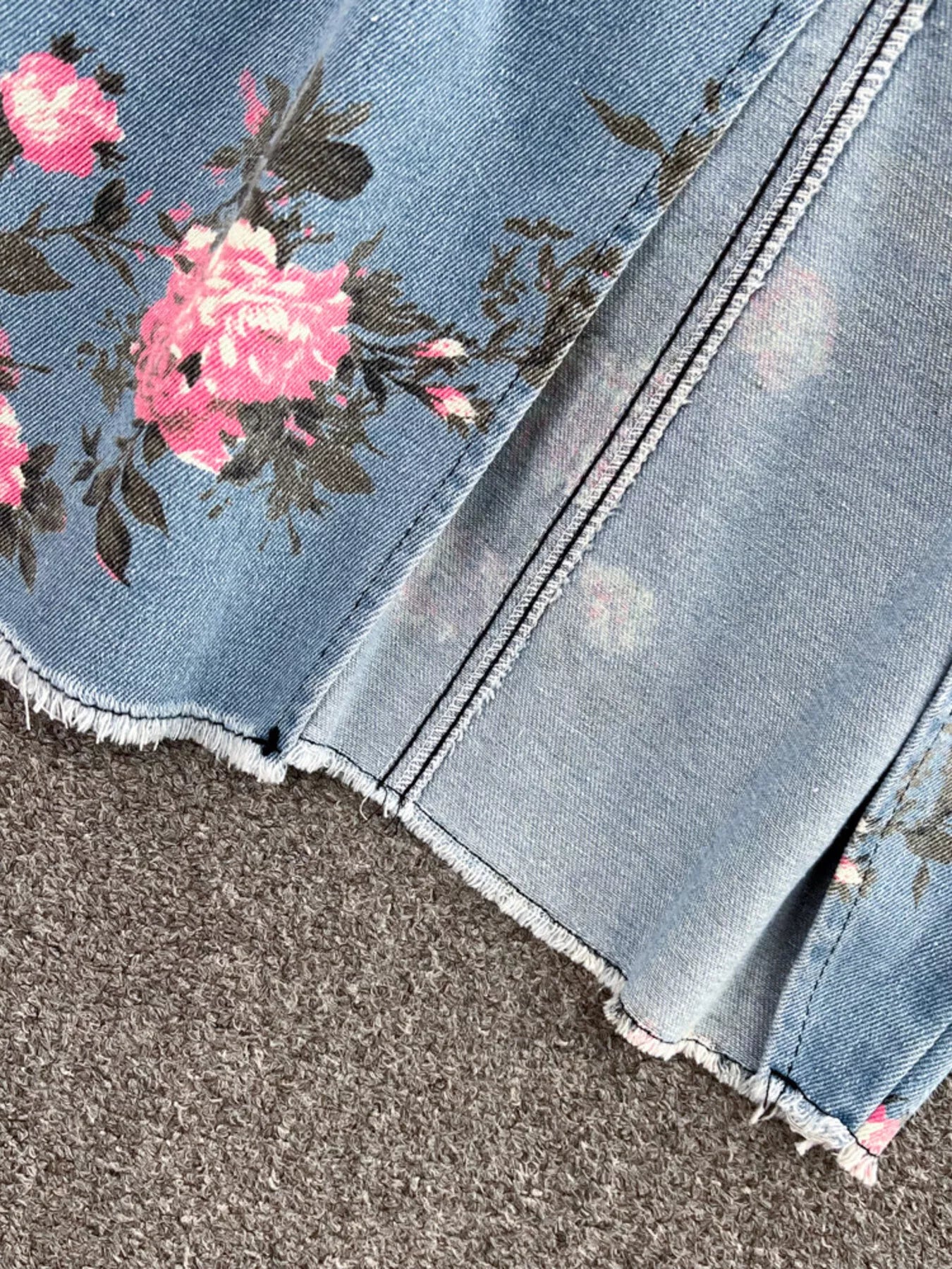 Blue denim skirt hem with pink floral border and raw-edged fray