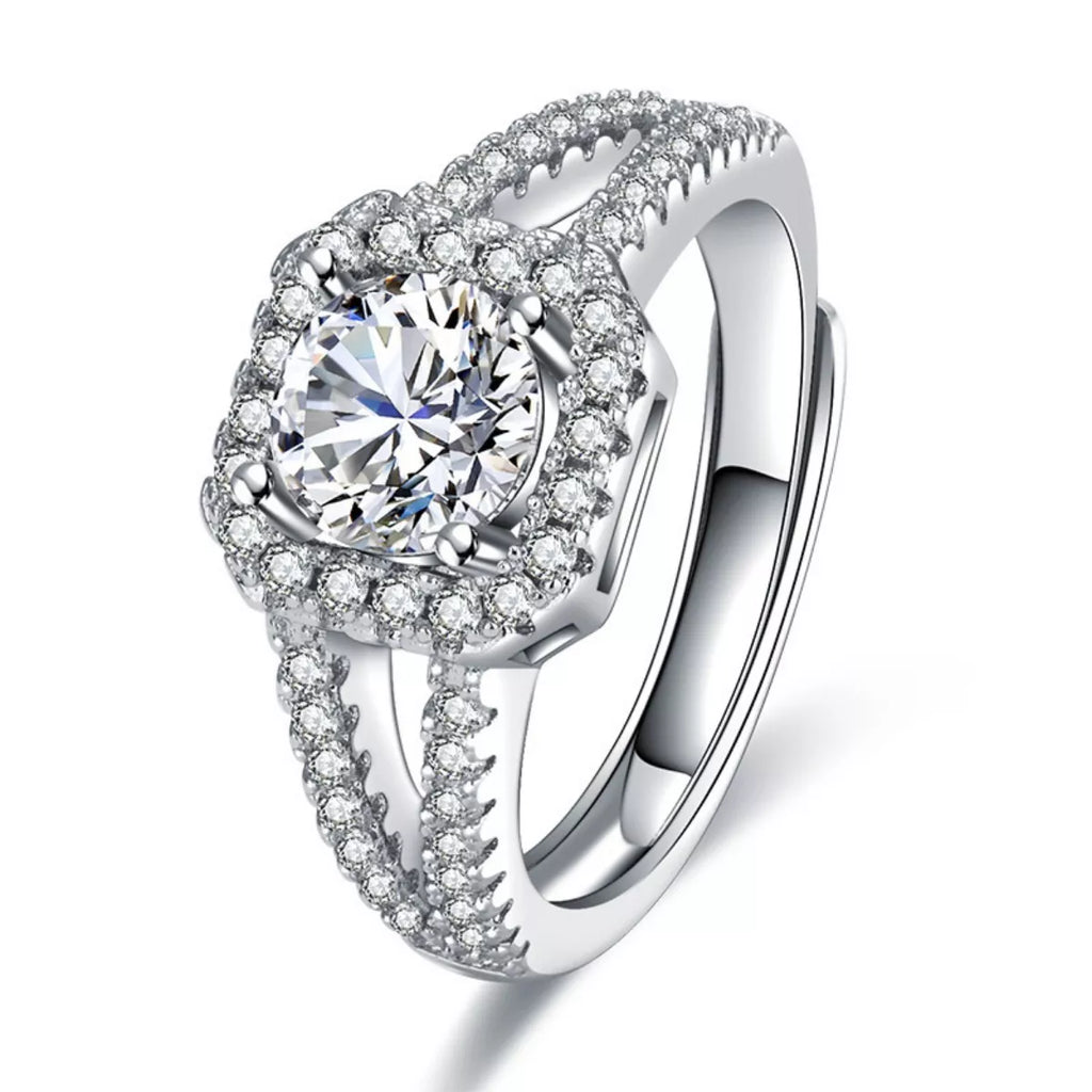 Close-up of 1-carat moissanite ring: round center stone, halo, and pavé shank