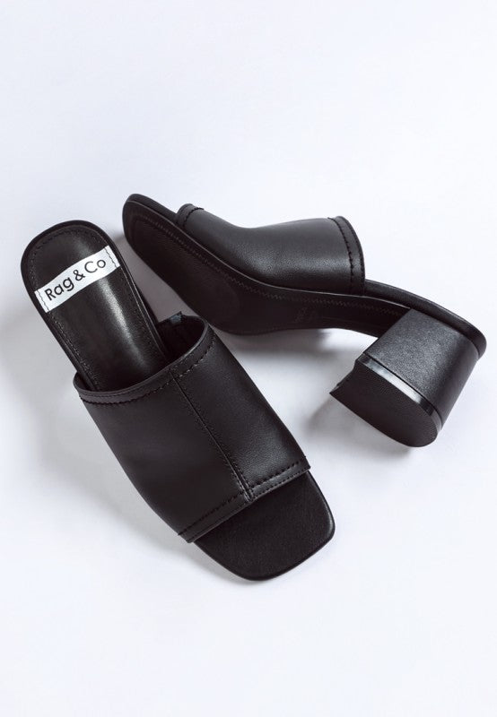 Black leather slip-on heels with open toe and wide block heel, side view