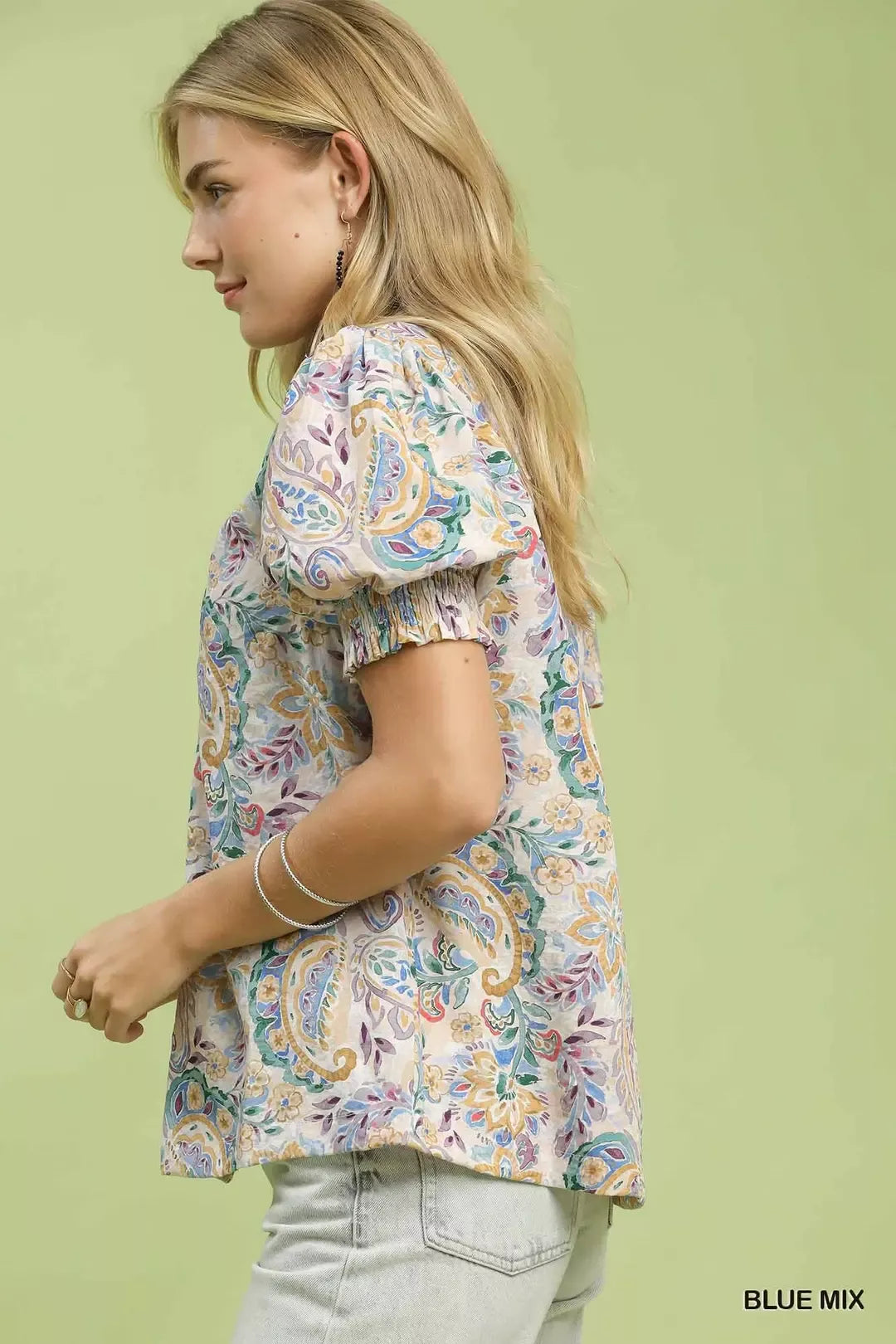 Side view of blue mix paisley floral button-down blouse with gathered puff sleeve