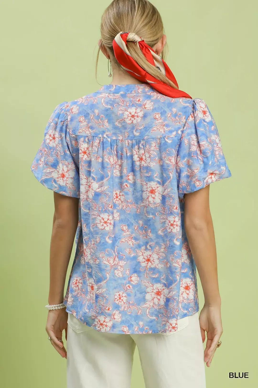 Back view of blue floral button-front short-sleeve shirt with gathered yoke