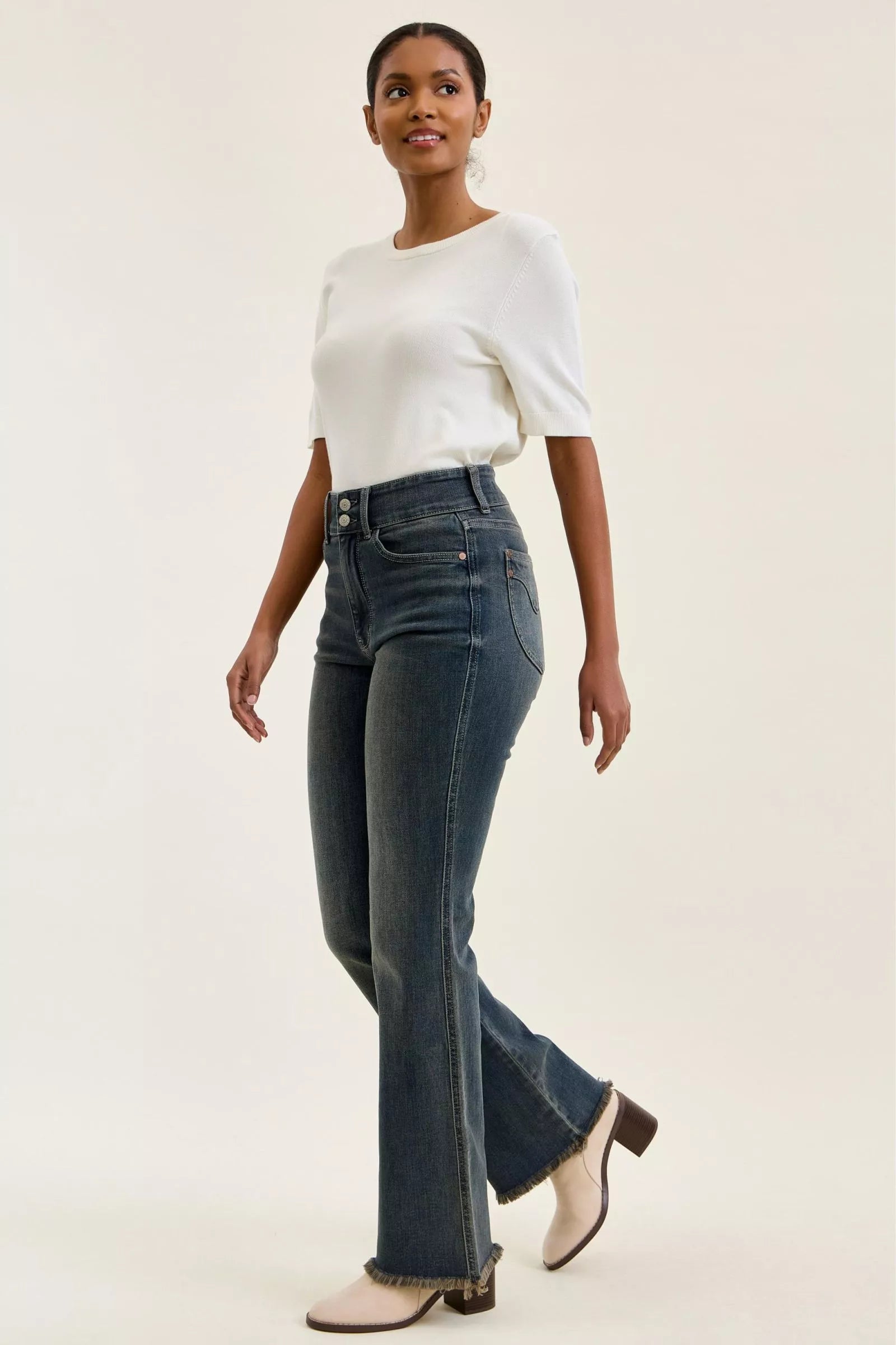 Front view of medium-wash high-waist jeans with angled pockets and frayed hem