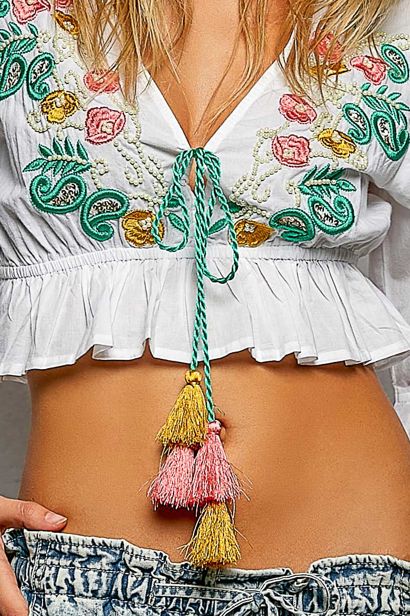 Ivory blouse front with colorful floral embroidery and green drawstring tassel