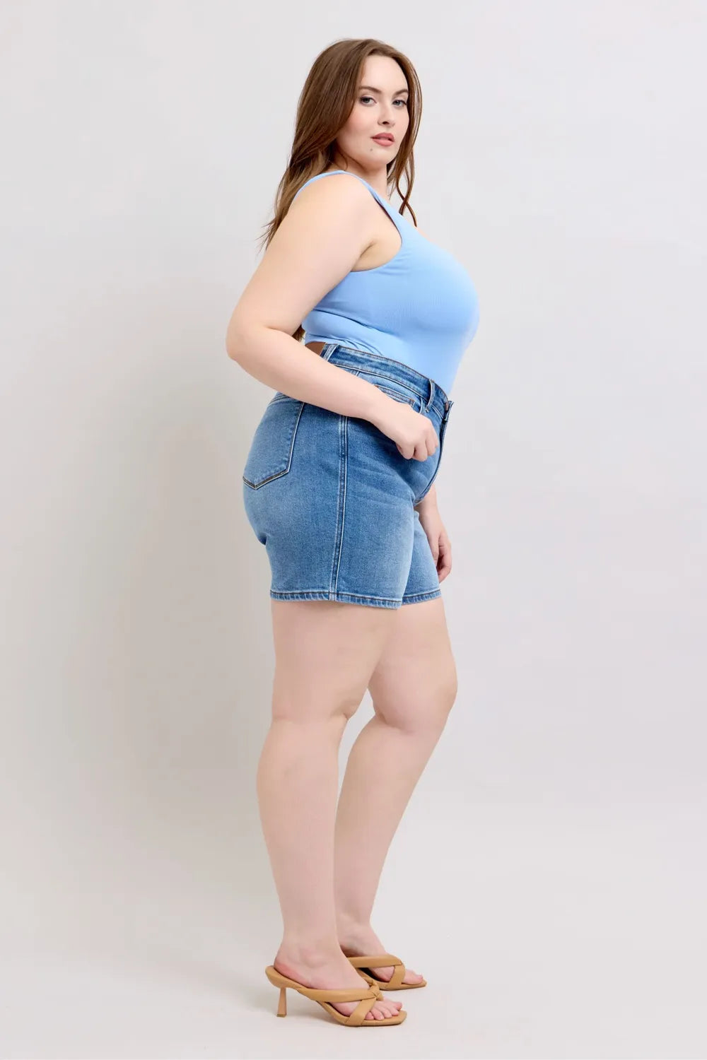 Medium wash denim shorts, angled side view; 2-button front and front pockets