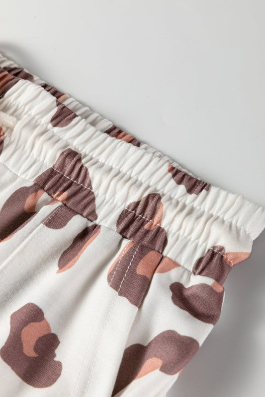 Elastic waistband with drawstring on white leopard-print pants