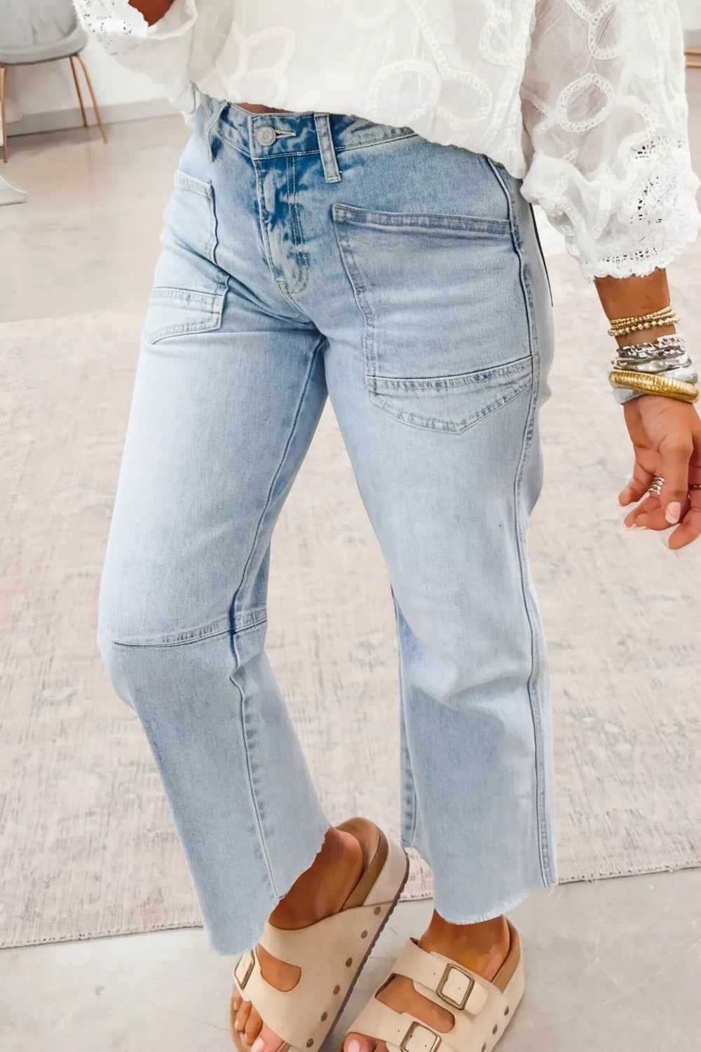 Light blue straight-leg jeans with utility pockets and faded wash across the thighs