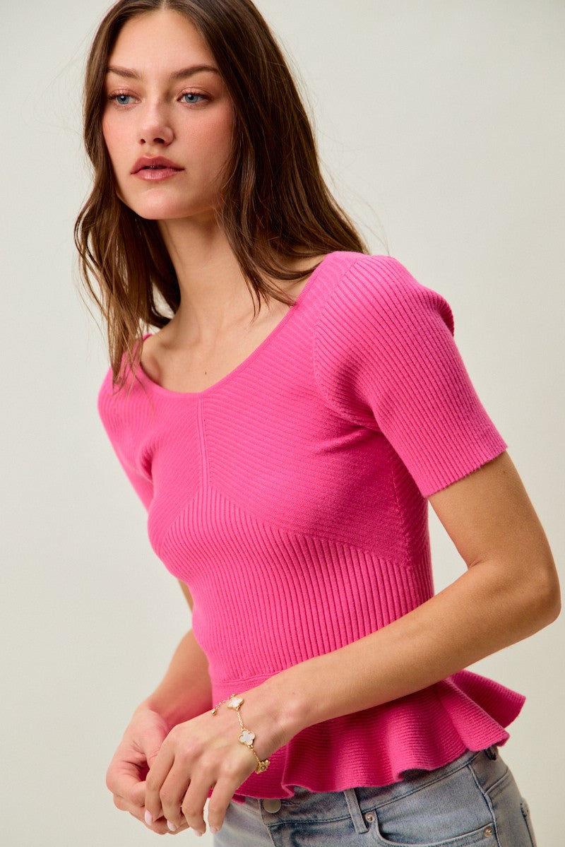 Hot pink ribbed knit peplum sweater top with short sleeves and peplum ruffle