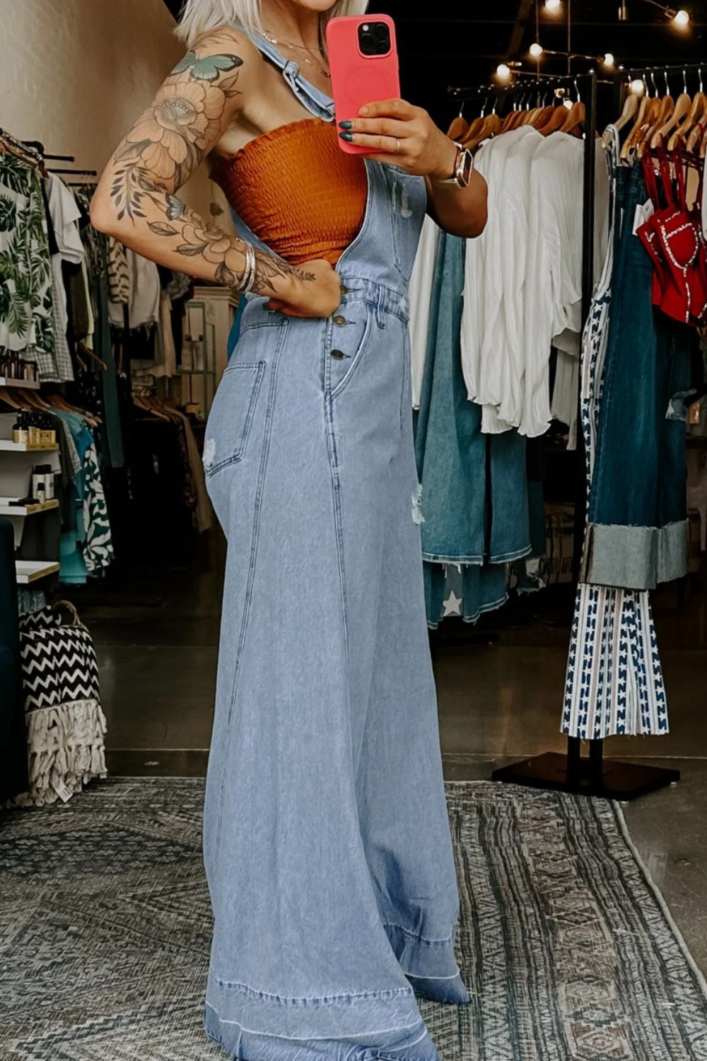 Light blue distressed denim overalls, sleeveless straps and wide leg silhouette