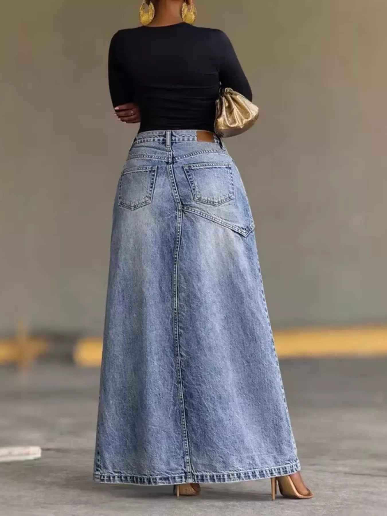 Blue high-waisted denim skirt with belt loops, front pockets, and button closure