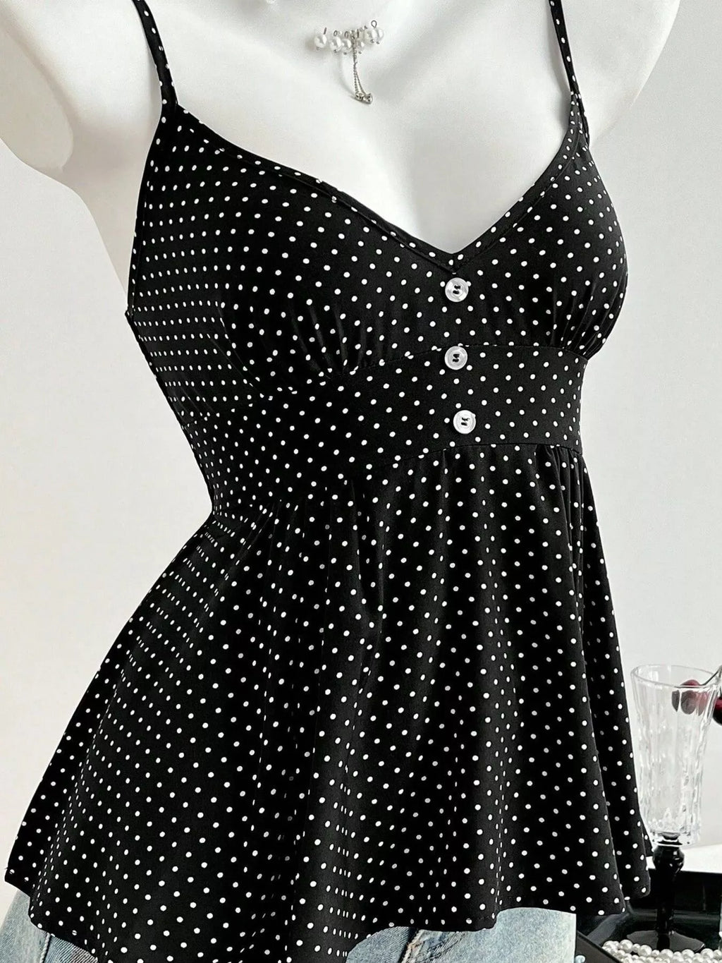 Black polka dot cami close-up: V-neckline and button placket on bust