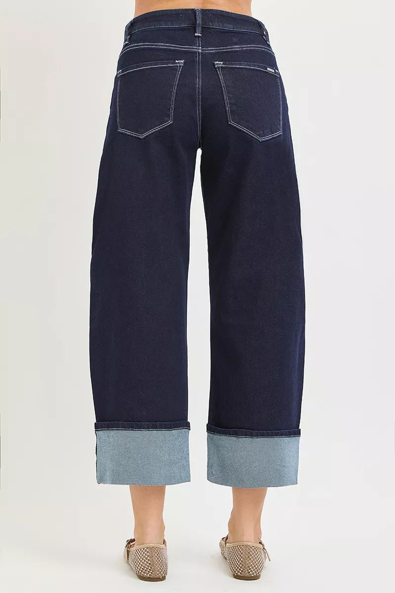 Back view of dark wash slouchy crop barrel jeans with cuffed light denim hem