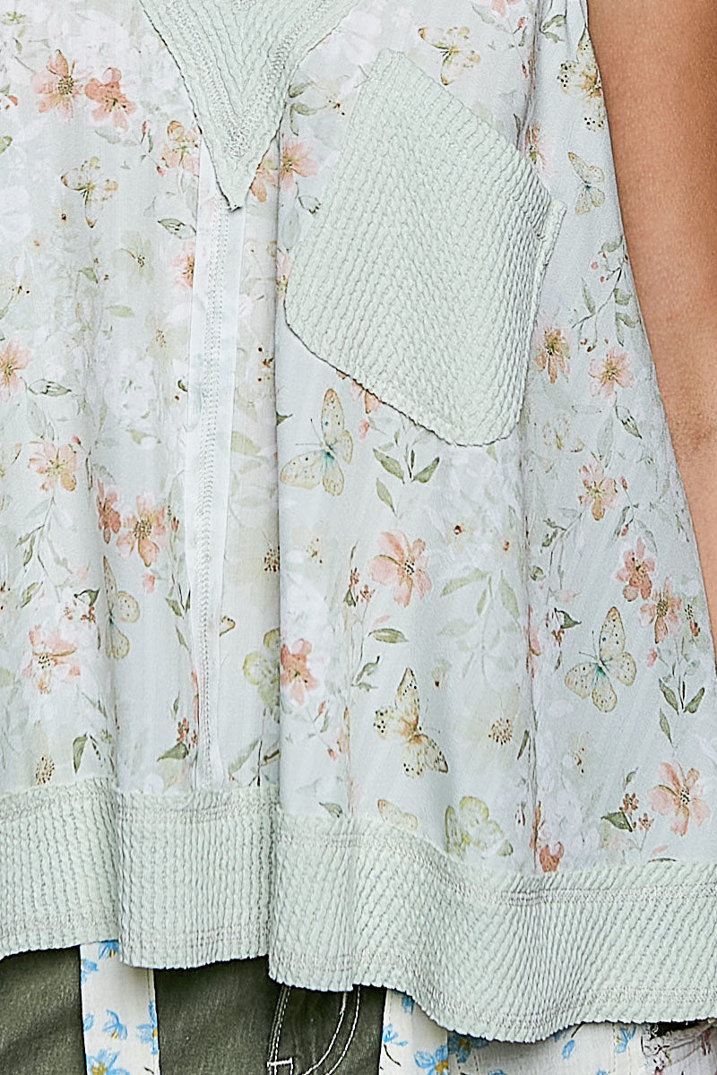 Close-up of sage multi floral tank: V-neck placket and textured front pocket
