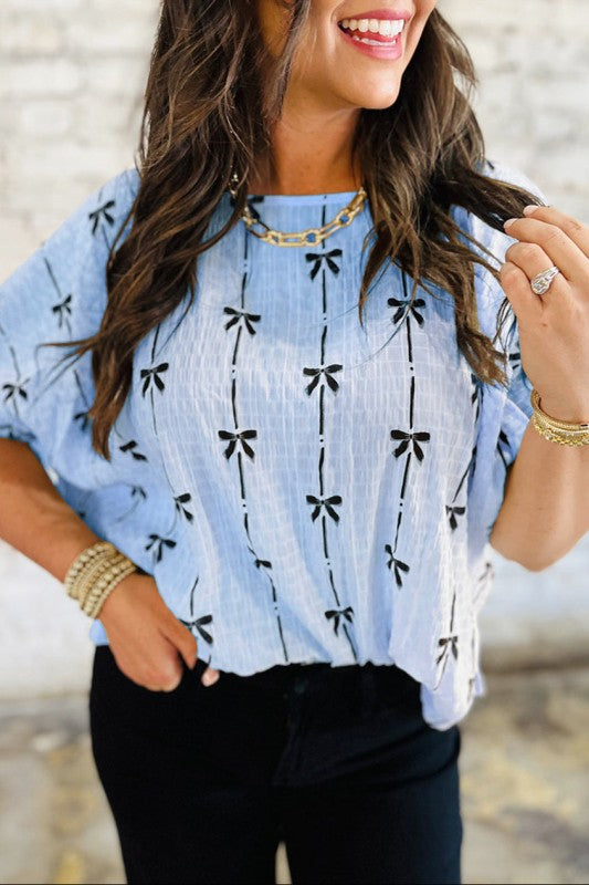 Beau Blue bow-texture top with black bow print, short puff sleeves, crew neckline