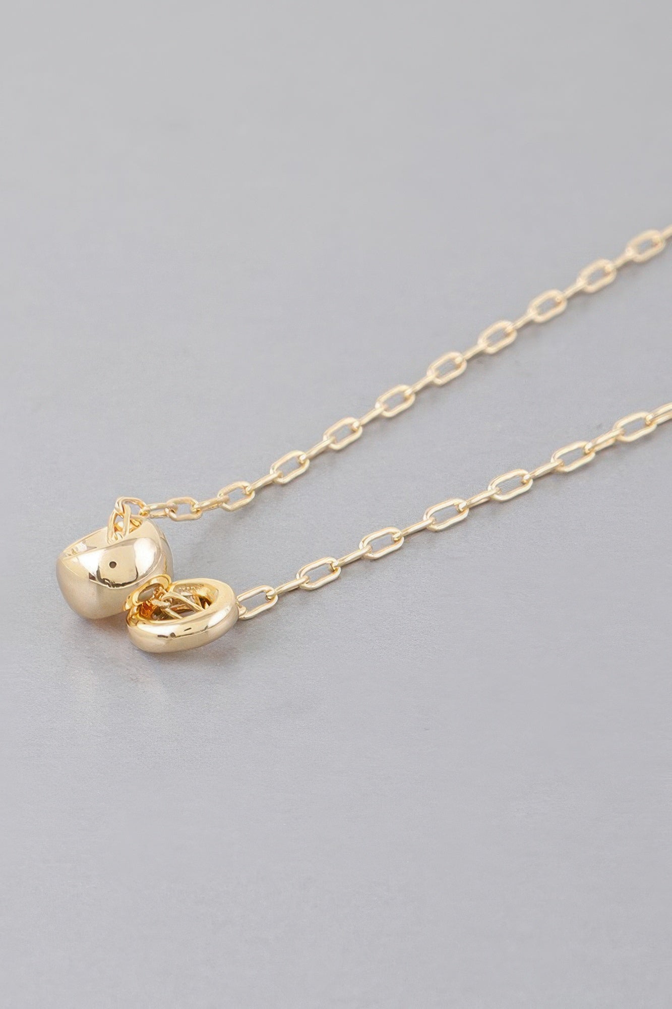 Gold-tone chain necklace with heart-shaped charm and side clasp detail