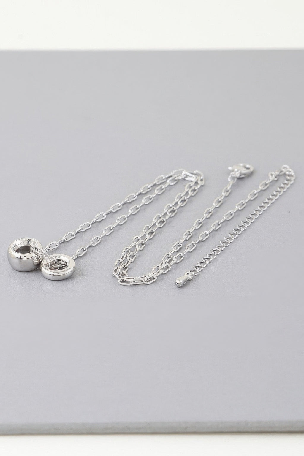 Silver-tone chain necklace with heart clasp charm and linked chain strands
