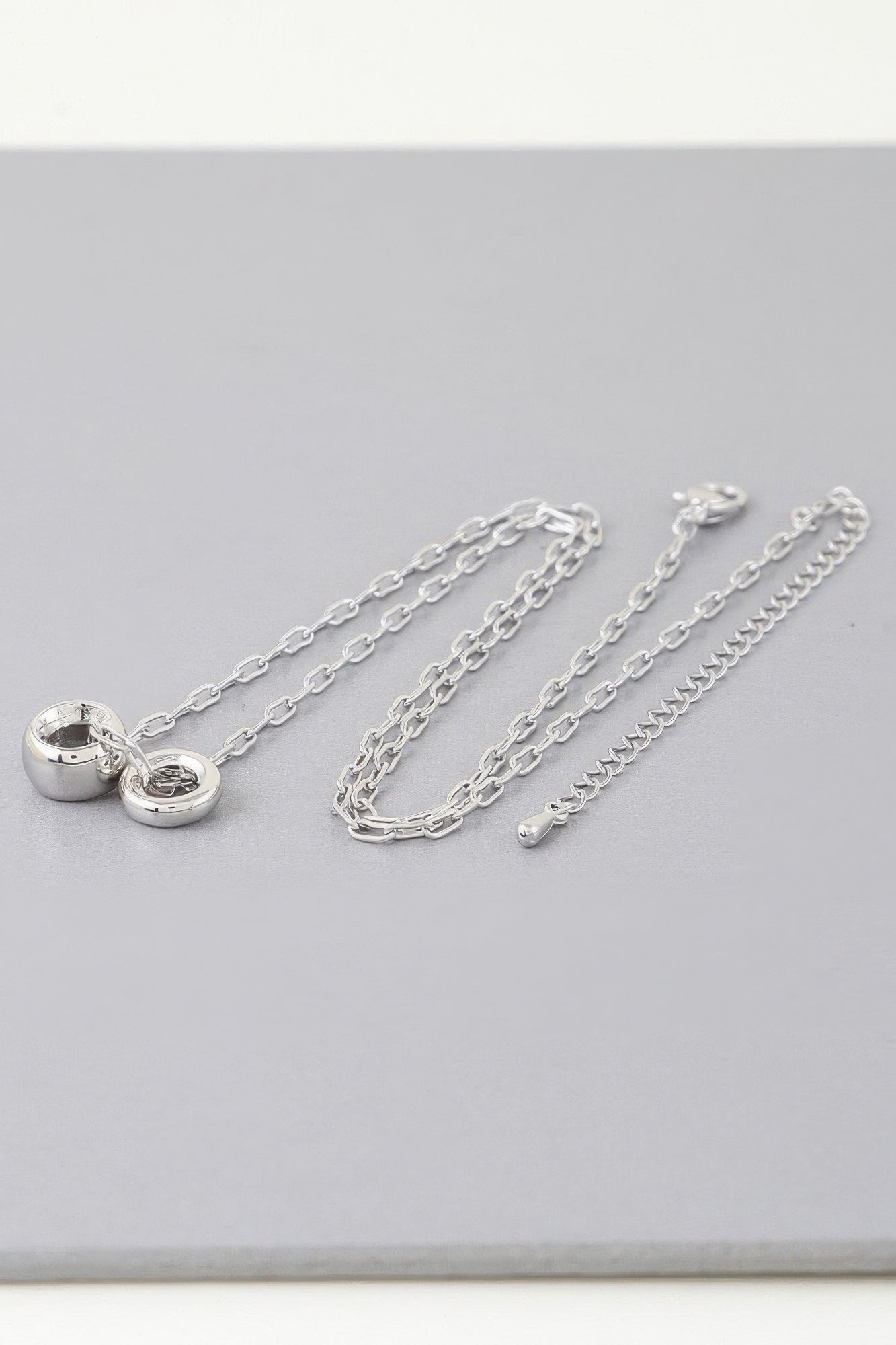Silver-tone chain necklace with heart clasp charm and linked chain strands