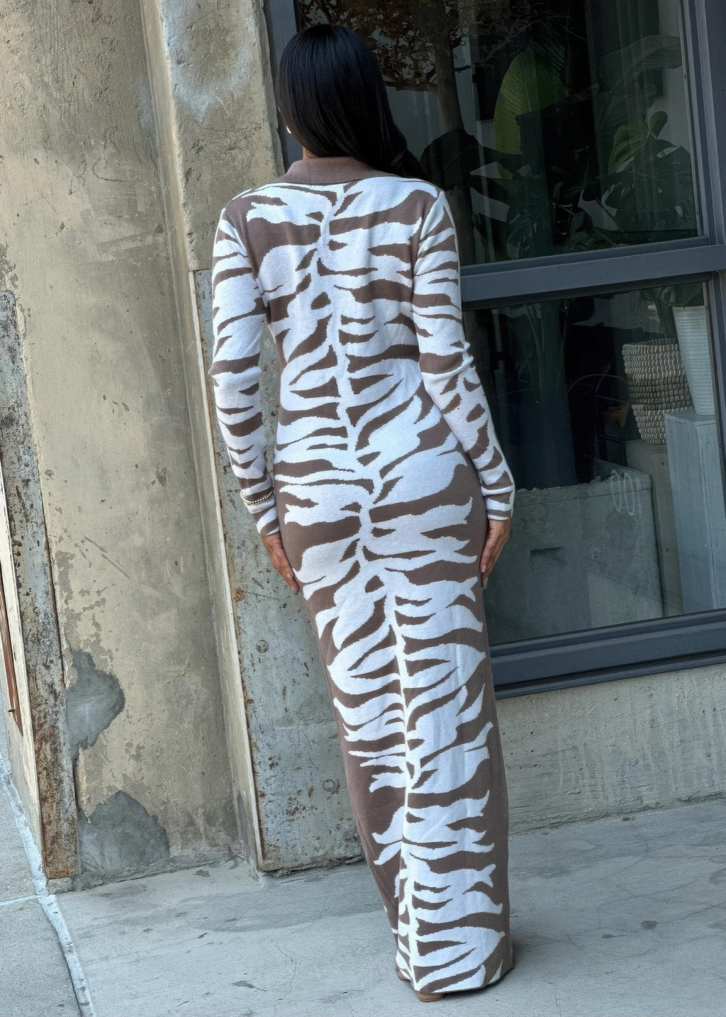 Back view of zebra print bodycon sweater dress with long sleeves and full-length zebra motif
