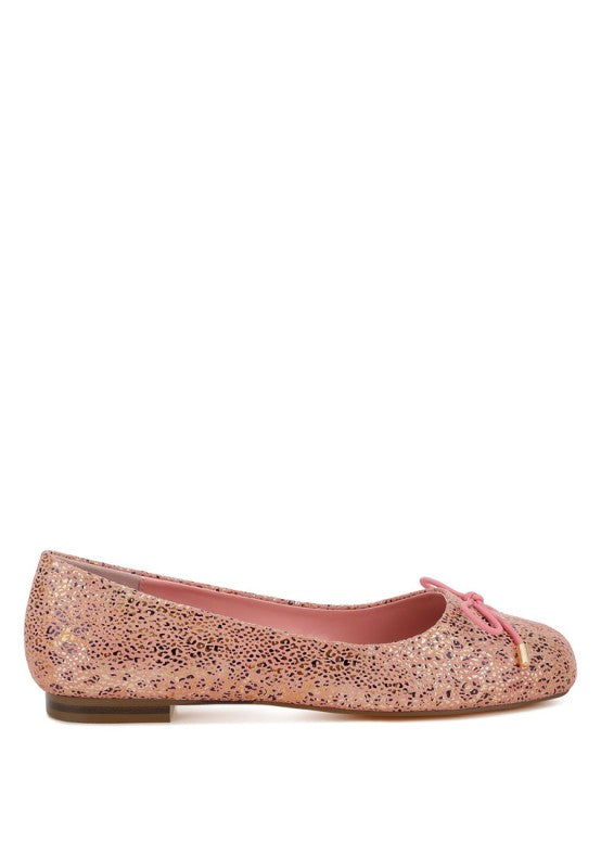 Side view of pink suede ballerina flats with bow tie and shiny speckle foil print