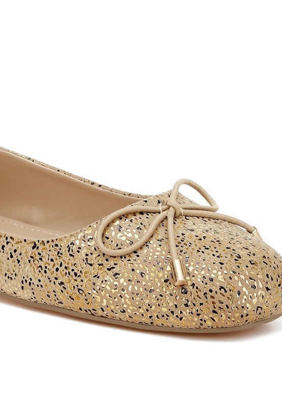 Close-up: gold foil-speckled suede ballerinas with bow at the vamp