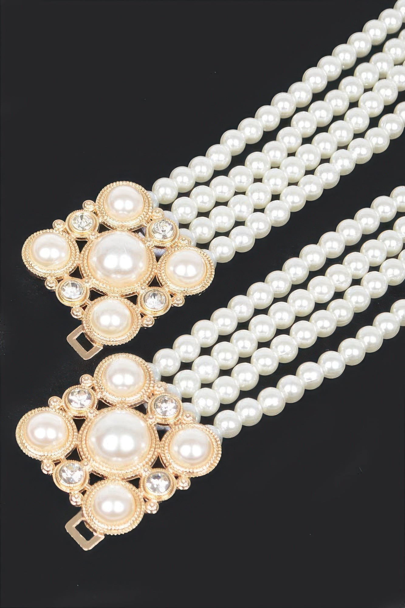 Close-up of cream faux pearl elastic belt with gold-toned ornate floral buckle and stones