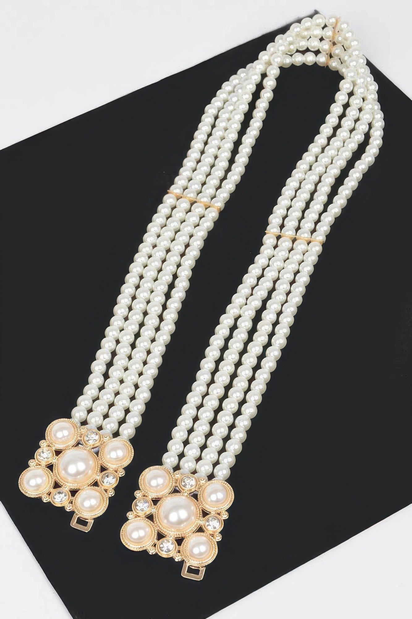 Cream faux pearl elastic belt with long pearl strands and gold-toned floral clasp ends