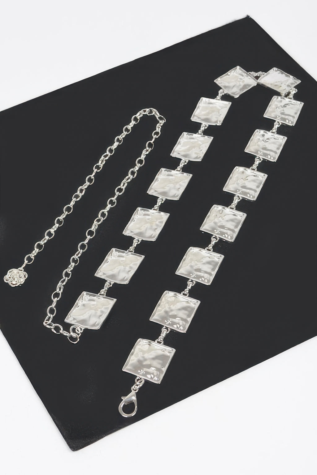 Silver hammered square chain belt set on flat surface, square-link rows and clasp