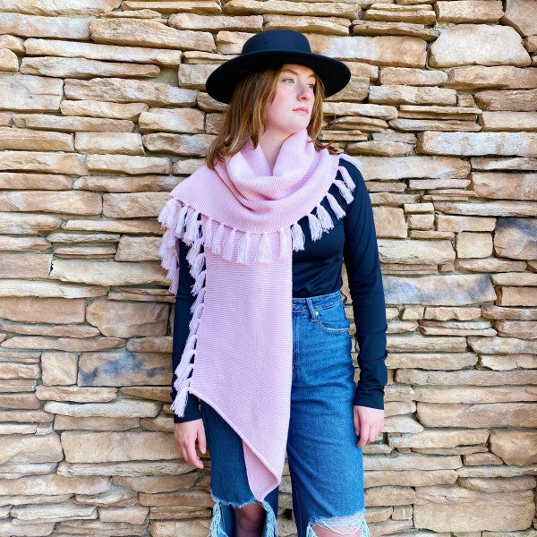 Pink fringed blanket scarf draped over shoulders, one-size knit wrap