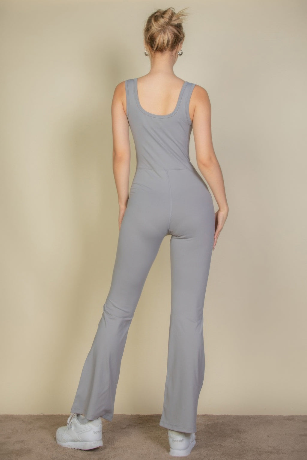 Back view of cement gray flare-leg sports jumpsuit, sleeveless scoop back