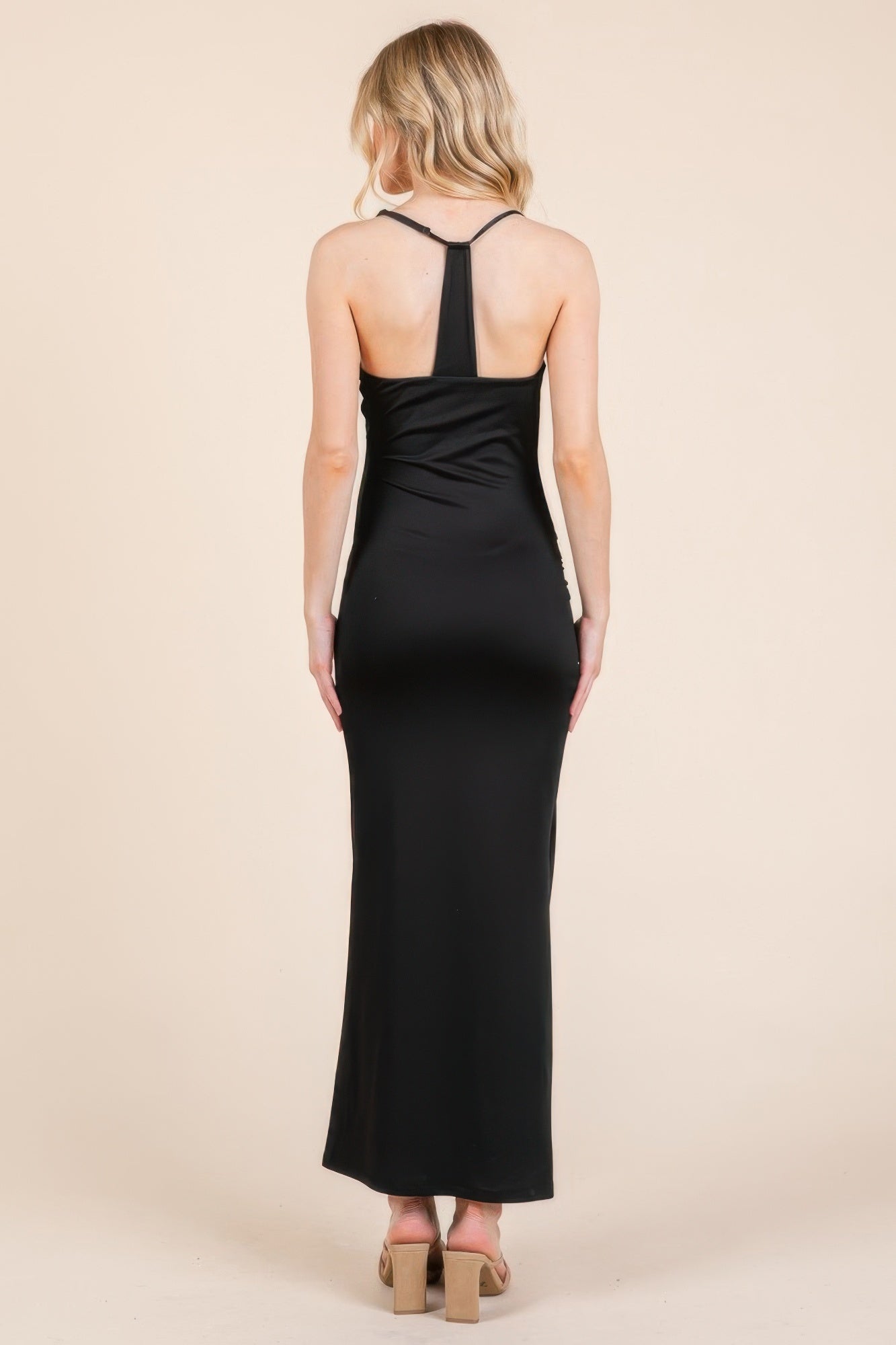Back view: black double-layer maxi dress with thin straps and ruched waist seam.