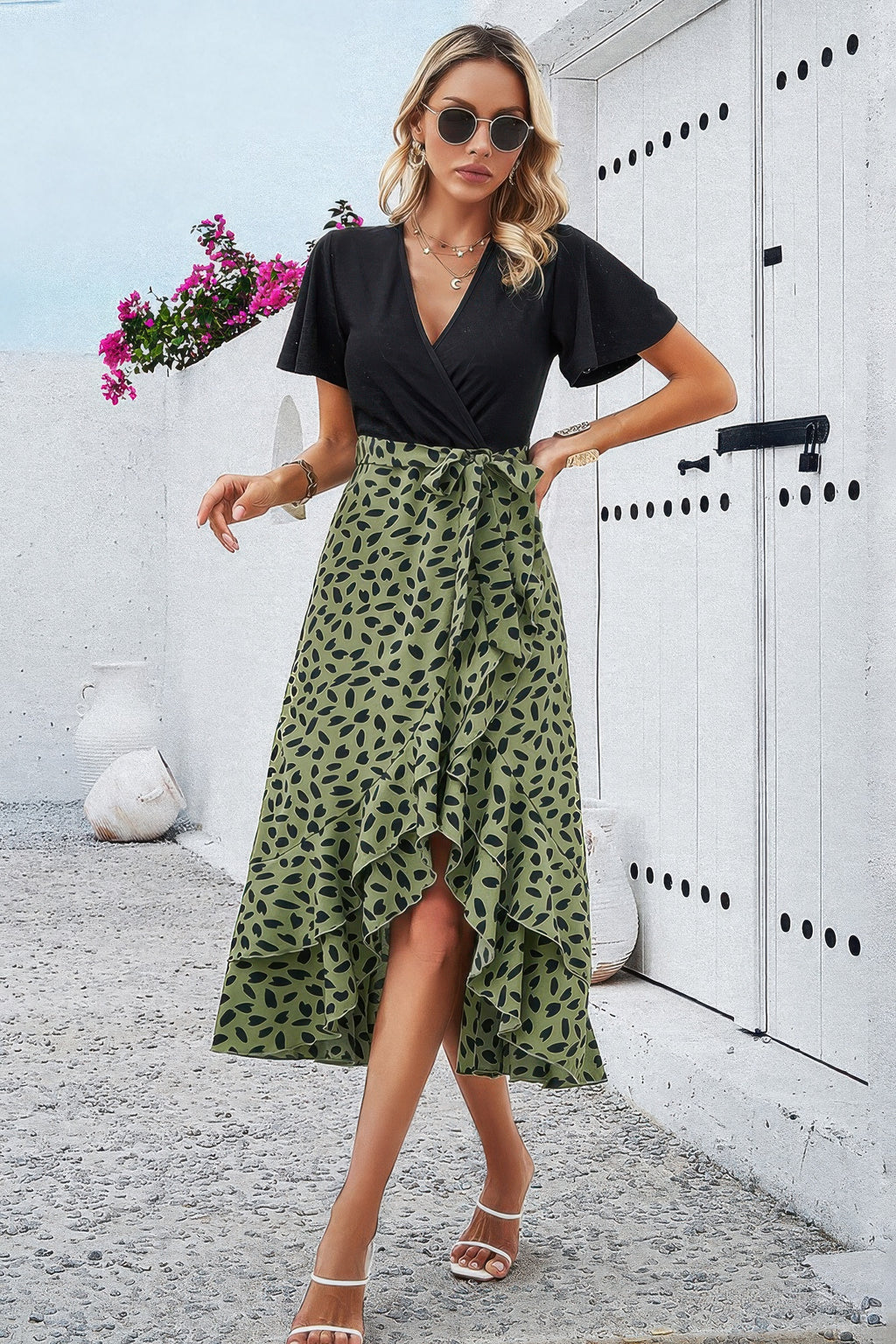 Black V-neck wrap dress with green leopard-print skirt and ruffled midi hem