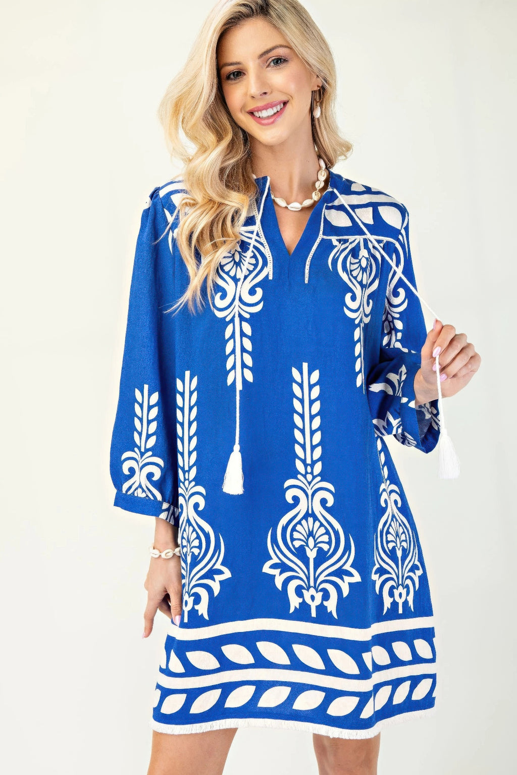 Blaues Kleid mit 3/4 Ärmeln, weißem Ornamente-Print und Quastenband am Ausschnitt