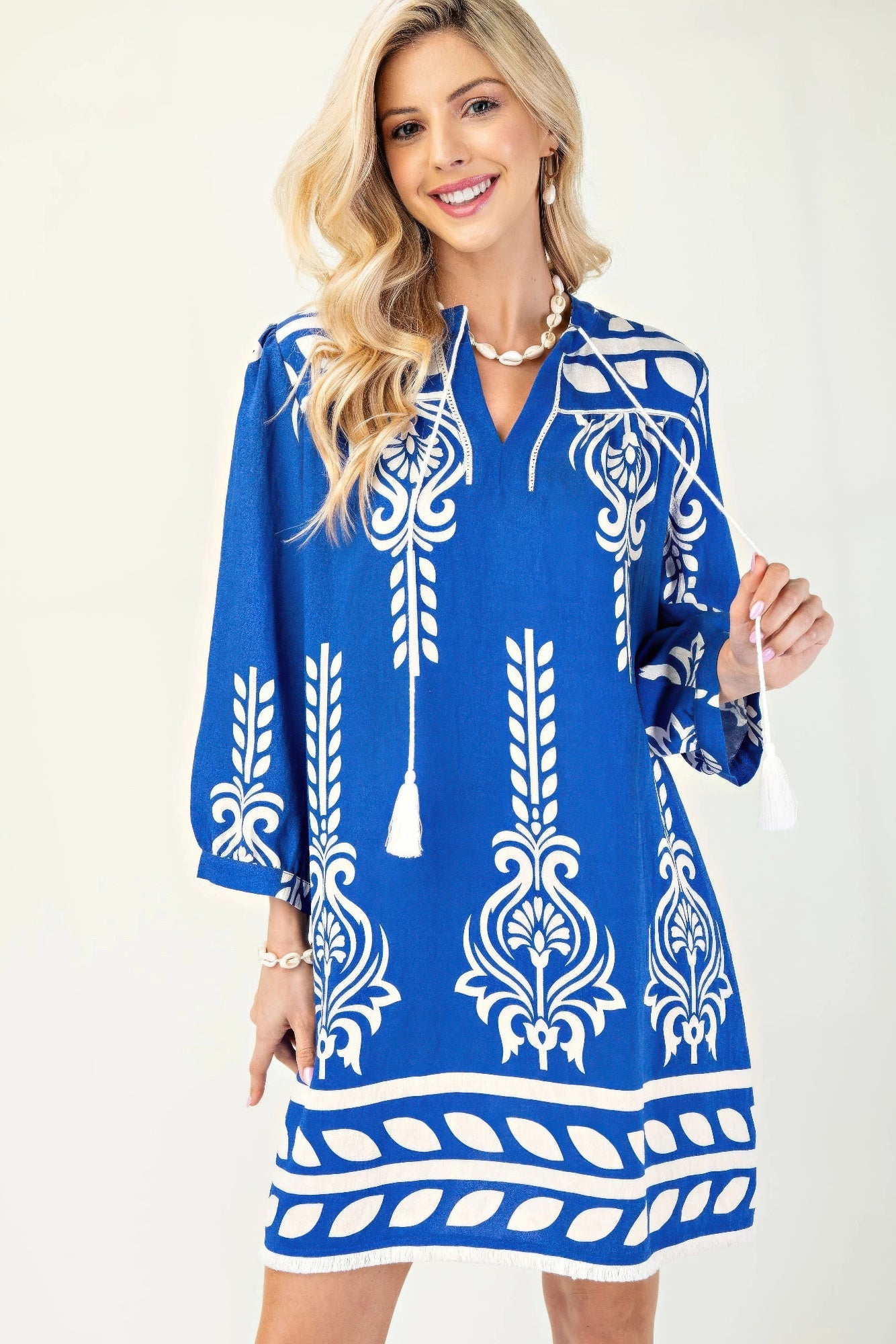 Blaues Kleid mit 3/4 Ärmeln, weißem Ornamente-Print und Quastenband am Ausschnitt