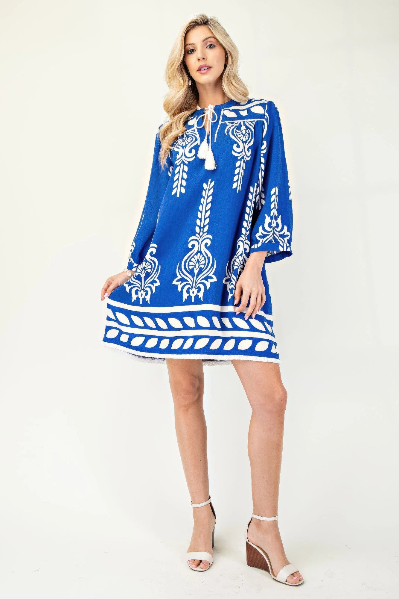 Blaues Kleid mit 3/4 Ärmeln, weißem Ornamentprint, Quastenband am Halsausschnitt