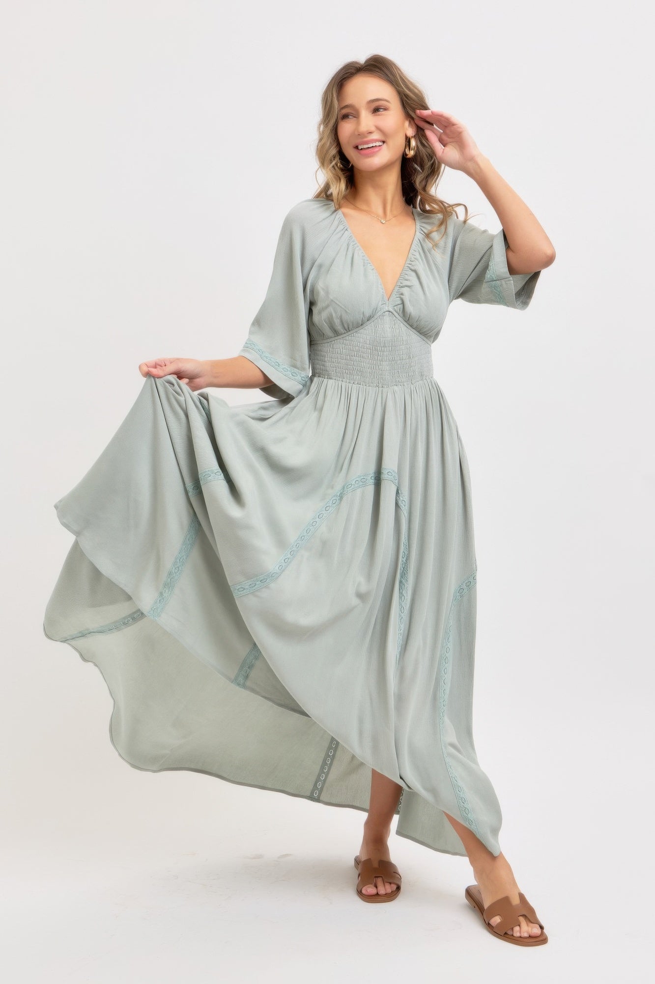 Dusty sage flowy maxi dress with V-neck bodice and embroidered trim along sleeves