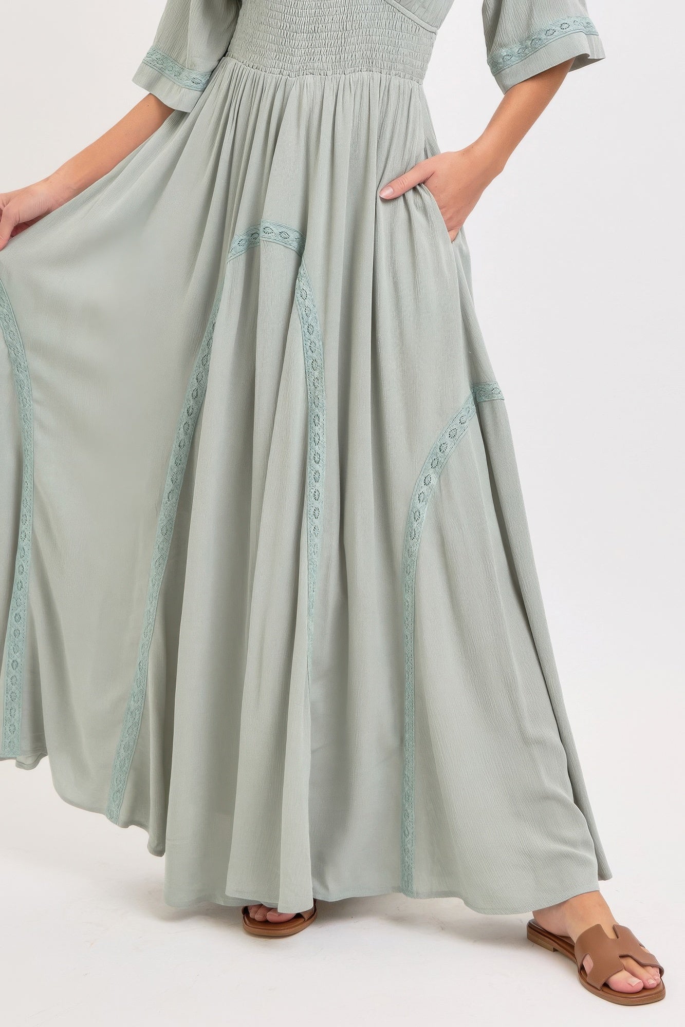 Dusty sage maxi skirt with vertical embroidered trim and soft, flowing pleats