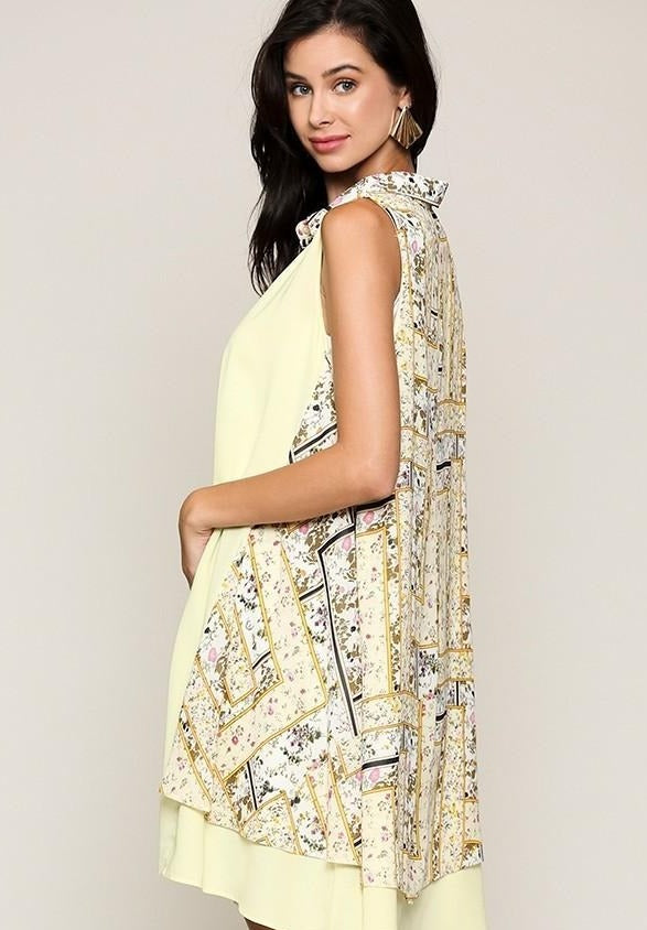 Yellow sleeveless collared dress side view with patchwork print along hem
