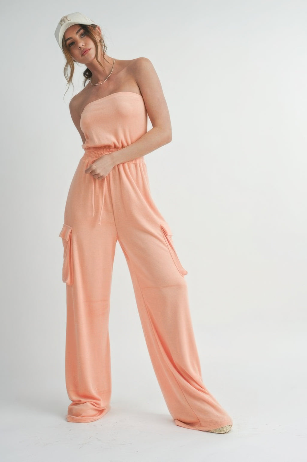 Peach tube top jumpsuit with elastic waist and cargo-style side pockets, wide legs