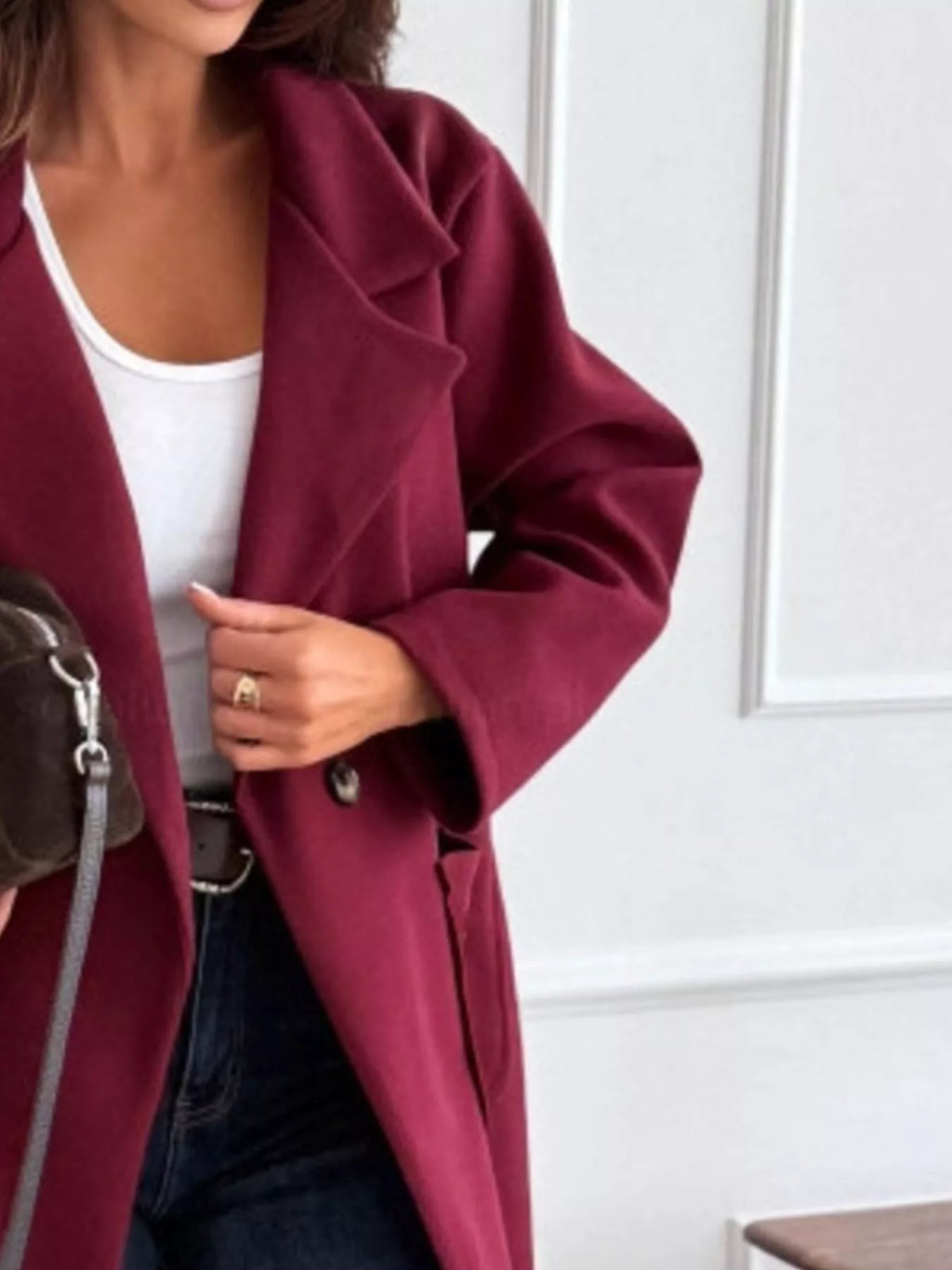Burgundy trench coat sleeve and collar detail with single-breasted front button