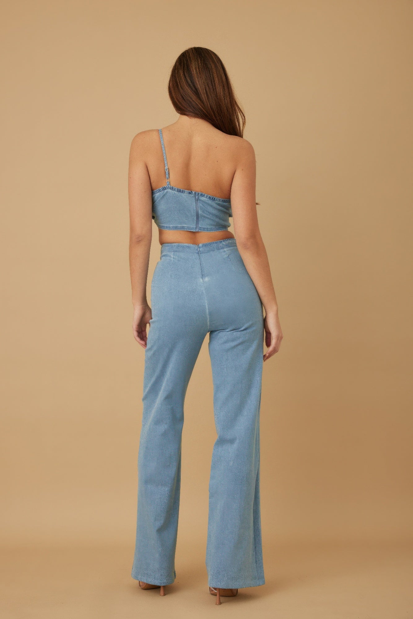 Back view: light denim blue single strap crop top with open back and wide-leg trousers