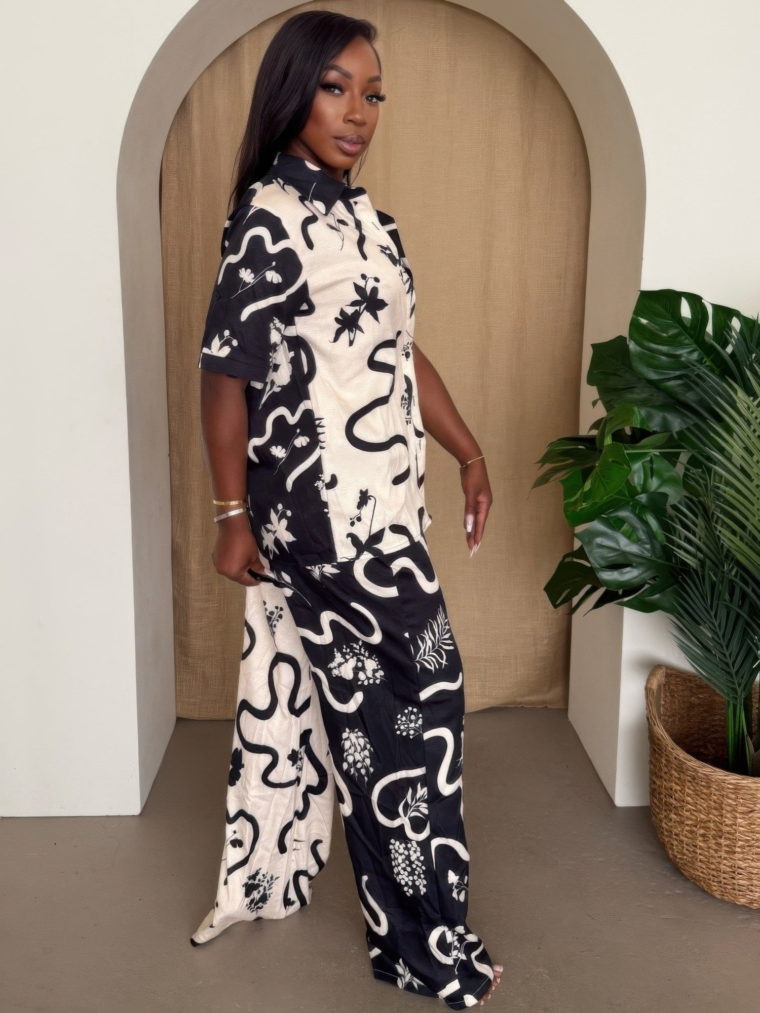 Side view of black/white printed resort pant set with short-sleeve button shirt and wide-leg pants